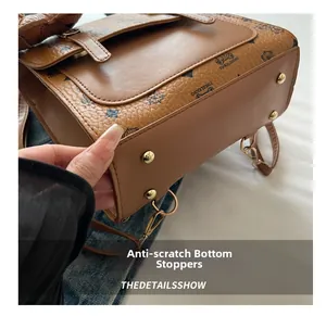 Close-up of bottom wear-resistant gold studs on a brown leather polka dot backpack