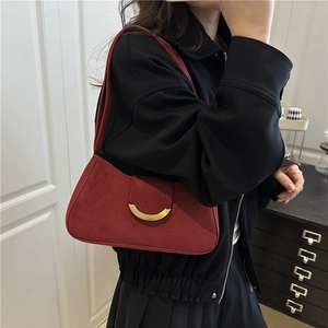 Retro burgundy suede underarm bag with gold metal buckle shown on model in casual style