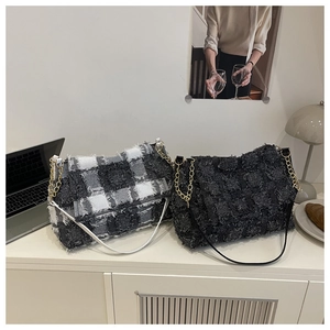 Detail view of tweed textured handbags with golden metal chain and leather straps