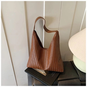 Detail of dark brown woven leather texture on a triangular hobo shoulder bag