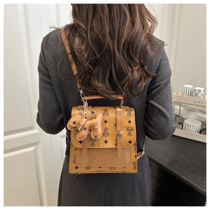 Brown vintage backpack with bear diamond print and elephant charm shown on back