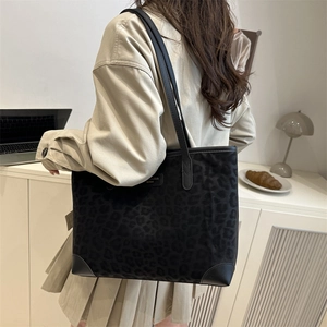 Große Shopper-Tasche mit Leopardenmuster und schwarzen Lederakzenten getragen von einem Model