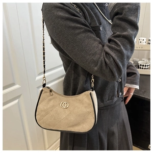 Detailed close-up of light brown crossbody bag with diamond stitching and golden hardware