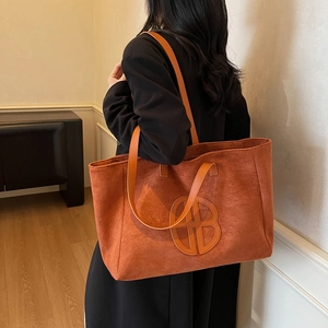 Retro large capacity tote bag in caramel suede leather with round cutout logo design