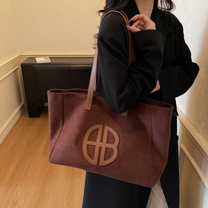 Retro burgundy suede tote bag with brown leather handles and circular logo detail