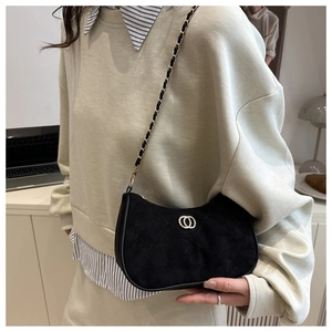 Detail of black suede hobo bag with gold metal chain strap and luxury ring logo