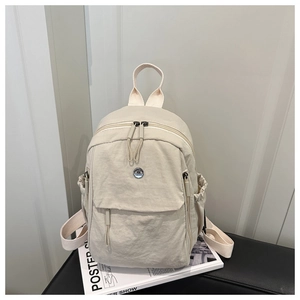 Détail du sac à dos en nylon imperméable blanc crème avec poches latérales à cordon