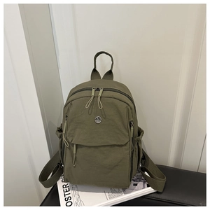 Vue détaillée du sac à dos en nylon vert olive avec logo M et poches latérales à cordon