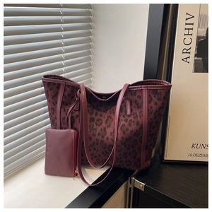 Detail of burgundy leopard print tote bag with leather straps and mini zipper pouch