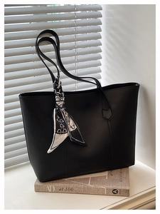 Detail of a large black matte PU leather tote bag with a decorative printed silk scarf
