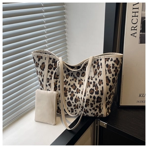 Detail shot of leopard print canvas tote bag with a small beige pouch and artistic shadows