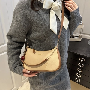 Sac bandoulière demi-lune beige avec breloque cerise et chaîne dorée élégante