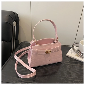 Detail of pink croc-embossed small square bag with golden lock and top handle