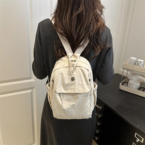 Zaino chic in nylon bianco crema con tasche multiple indossato da una modella