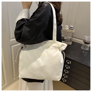 White waterproof nylon drawstring tote bag with Fashion label shown on a model