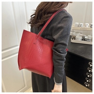 Detail shot of the large red tote bag featuring premium crocodile texture on high-quality faux leather