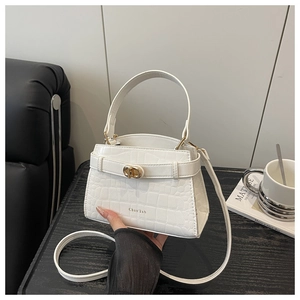 Detail showing white crocodile texture faux leather bag with golden metal twist lock