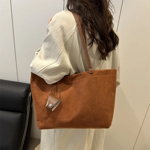 Minimalist large capacity caramel tote bag with matching pouch shown on shoulder