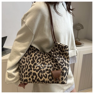 Gros plan du sac cabas en toile à imprimé léopard avec bandoulières en cuir marron