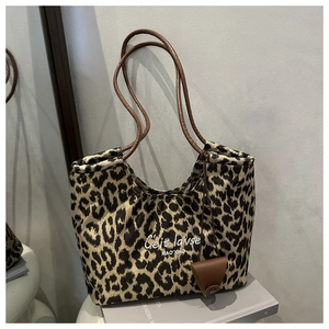 Close-up of leopard print suede tote bag featuring refined embroidery and leather strap