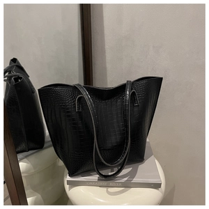 Close-up of black crocodile embossed texture on a structured minimalist tote bag