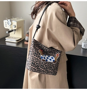 Détail du sac seau léopard avec broderie teckel et bandoulière en cuir à nœuds élégante