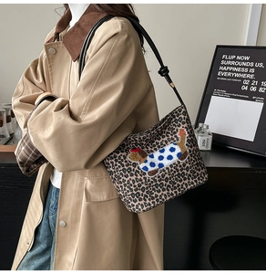 Détail du sac seau léopard avec broderie teckel et bandoulière en cuir noué