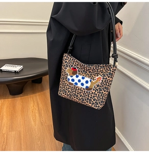 Détail du sac seau à imprimé léopard avec broderie de teckel et fine bandoulière noire
