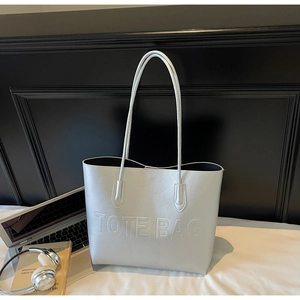 Détail du sac cabas argenté métallisé avec texte TOTE BAG en relief et fines bandoulières