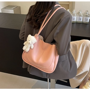 Pink leather square bag detail with a cute white plush bear pendant and soft textures