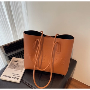 Gros plan d'un sac cabas en cuir marron avec texte gaufré dans un décor de style moderne