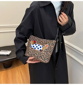 Détail du sac bandoulière léopard avec un patch brodé 3D d'un chiot mignon dessus