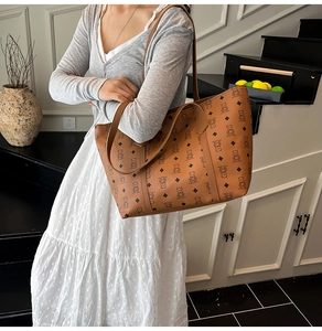 Brown tote bag with cartoon bear and diamond pattern worn by model on stairs