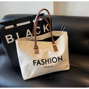 Detalle del bolso tote de lona con asas de cuero marrón y estampado Fashion Paris