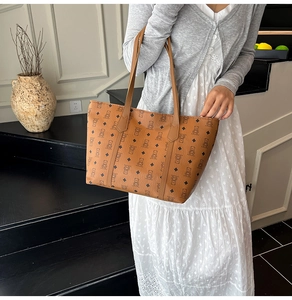 Brown leather tote bag featuring a cute bear monogram print with long shoulder straps