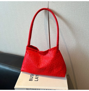 Detail of red woven leather shoulder bag showing the premium Intrecciato texture