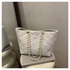Détail du sac cabas matelassé blanc avec bandoulière chaîne dorée et cuir souple
