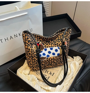Détail du sac seau à imprimé léopard avec broderie chien dans un coffret cadeau chic