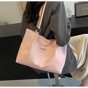 Detail of pink tote bag showing unique pleated PU leather texture and silver ring hardware