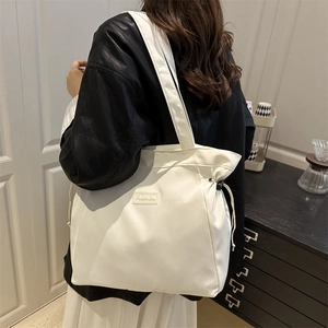 Minimalist white tote bag with drawstring detail and fashion patch for daily commuting