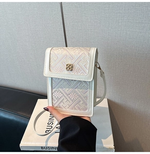 Close-up of elegant floral embroidery and gold clover buckle on the mini crossbody bag