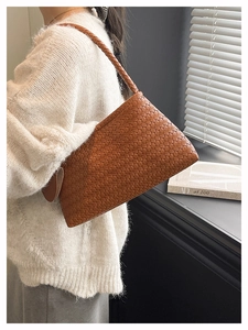 Dettaglio della trama intrecciata marrone e della tracolla larga di questa borsa hobo
