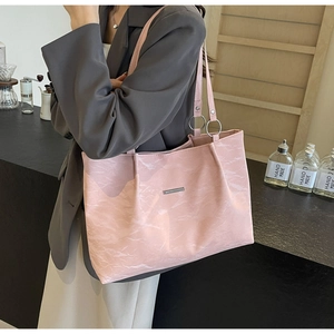 Pink oversized tote bag with marble texture shown on shoulder with grey blazer