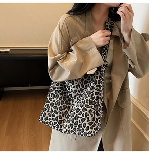 Detail of the leopard print tote bag with wide strap and fashion tag on trench coat