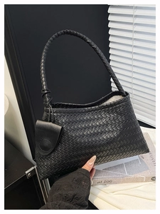 Dettaglio della trama in pelle intrecciata nera su una borsa sottobraccio vintage