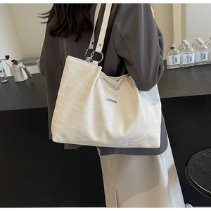 Detail of white large capacity tote bag featuring silver ring hardware and soft texture