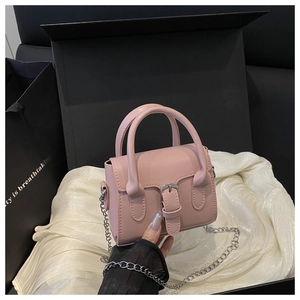 Detailed view of a mini pink structured handbag with silver chain strap in a gift box