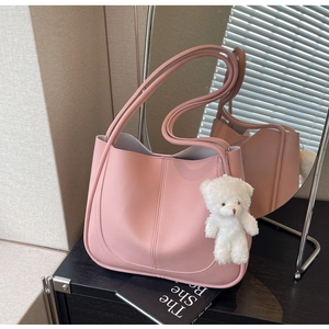 Pink matte leather square handbag with twin handles and a cute plush bear charm
