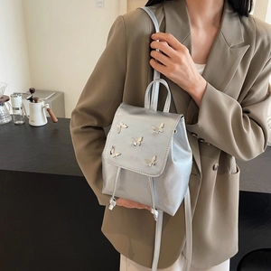 Chic silver mini backpack with 3D metal butterfly accents and matte metallic finish