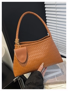 Dettaglio della borsa tote in pelle intrecciata color caramello con trama a griglia